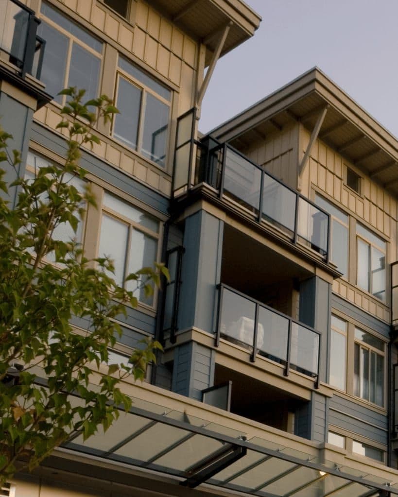 Un immeuble à logements de plusieurs étages, balcons et fenêtres en façade.