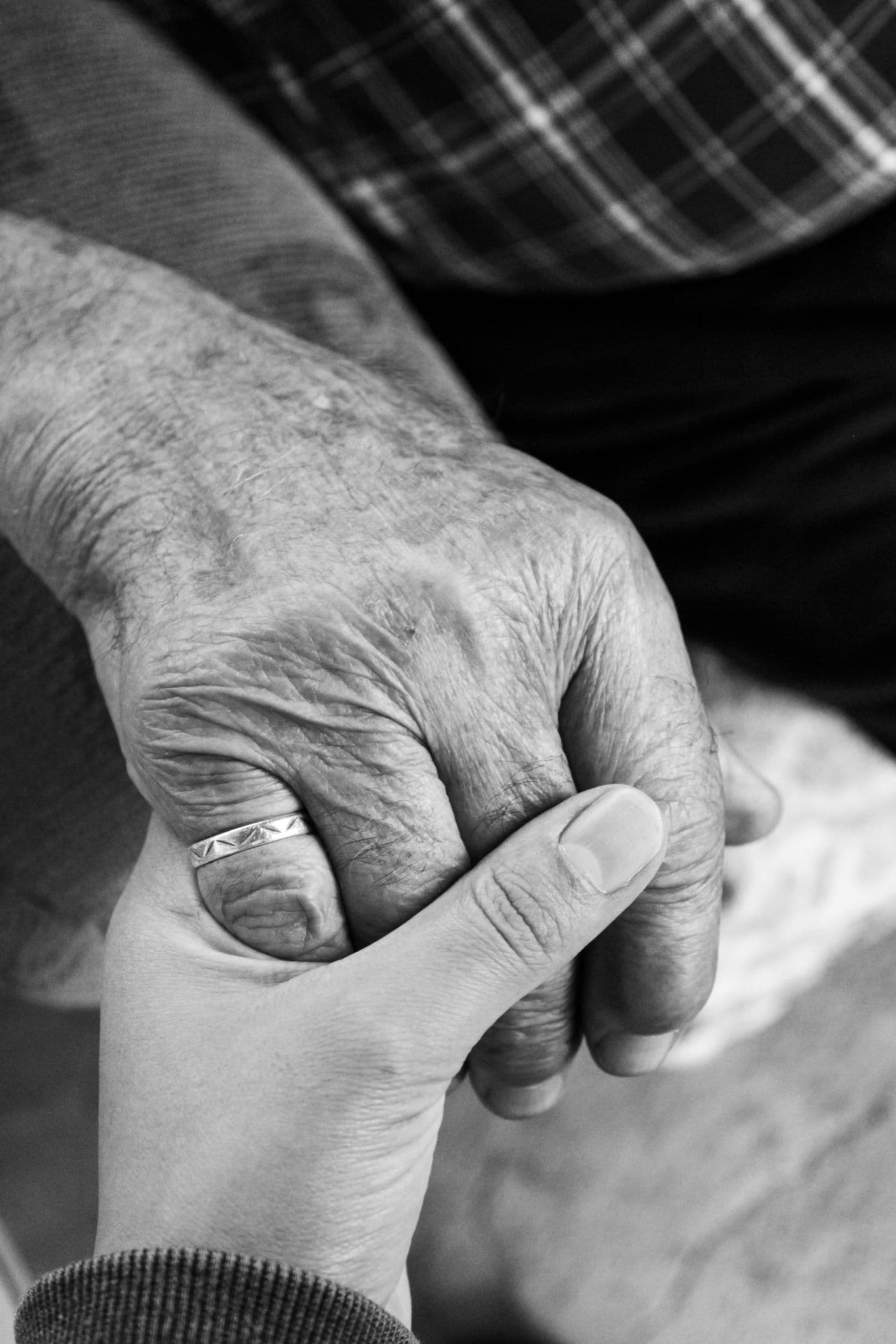 Une main jeune tient la main d’une personne âgée.